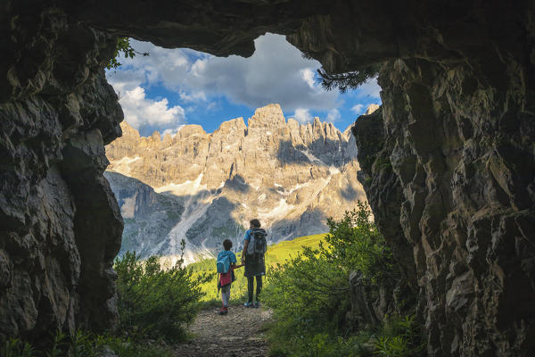 Mother and child admire the Pale di San Martino, glimpse from a cave along the path, Pala group, Dolomites, Trentino Alto Adige, Italy