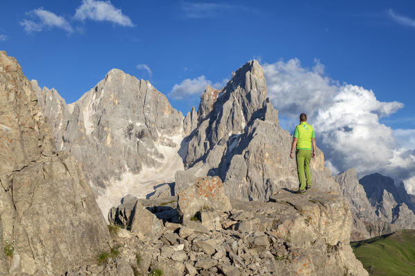 hiker standing admires the Cimon della Pala and Vezzana from a lookout on Castellazzo mountain, Dolomites, Trentino Alto Adige, Trento, Italy