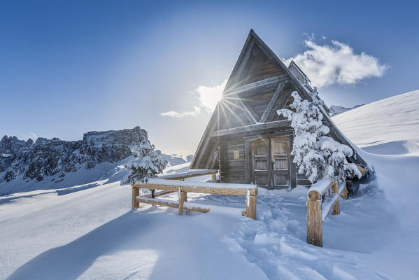 the small alpine wooden chapel at the giau pass after a heavy snowfall, Dolomites, Colle Santa Lucia, Belluno, Veneto, Italy