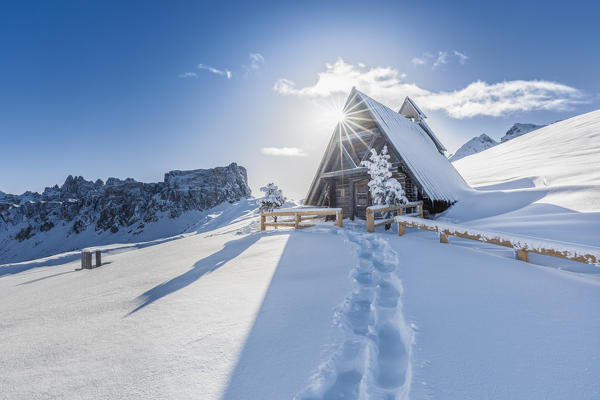 the small alpine wooden chapel at the giau pass after a heavy snowfall, Dolomites, Colle Santa Lucia, Belluno, Veneto, Italy