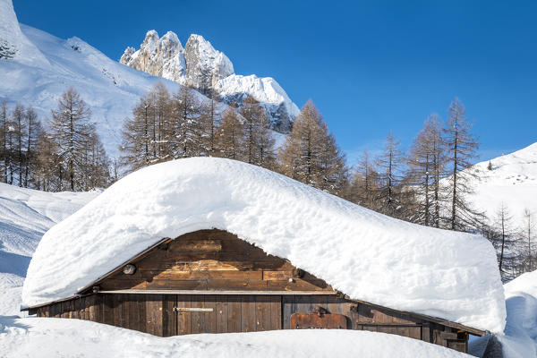 landscape of snow-covered mountain huts in the locality Ciamp de Lobia, Fedaia pass, Rocca Pietore, Marmolada, Dolomites, Belluno, Veneto, Italy