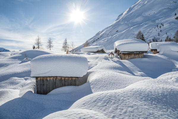 landscape of snow-covered mountain huts in the locality Ciamp de Lobia, Fedaia pass, Rocca Pietore, Marmolada, Dolomites, Belluno, Veneto, Italy