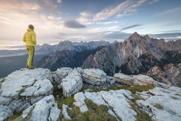 hiker admires the light of sunrise towards the Cadini di Misurina, Auronzo di Cadore, Belluno, Veneto, Italy