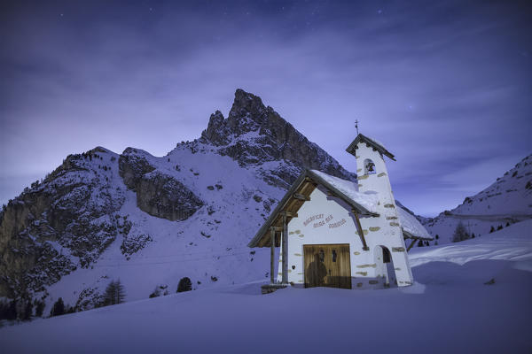 Europe, Italy, Veneto, Belluno. Alpine church of the Visitation in a winter night. Passo Falzarego, Dolomites