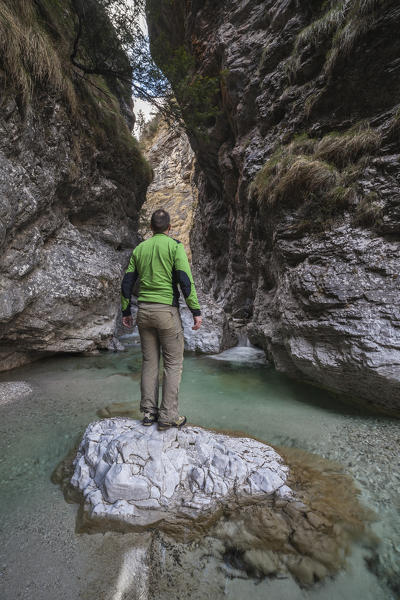 Dolomites, Belluno, Veneto, Italy. Hiker admires the narrow gorge of the Val soffia, Mis valley