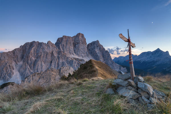 Europe, Italy, Veneto, Cadore.  The summit cross on the Col de la Puina at sunset with mount Pelmo in the background, Dolomites
