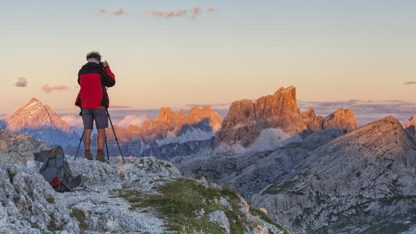 Europe, Italy, Veneto, Belluno, Cortina d Ampezzo. Landscape photographer at sunset on the top of Sass de Stria, Dolomites