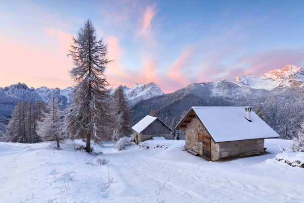 Europe, Italy, Veneto, Belluno, Dolomites. Mountain chalets in a colorful winter sunrise, Zoldo valley