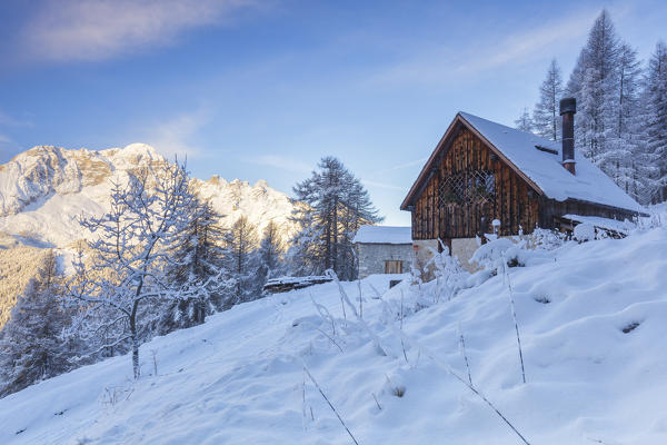 Europe, Italy, Veneto, Belluno, Dolomites. Typical mountain chalets in a winter sunrise, Zoldo valley