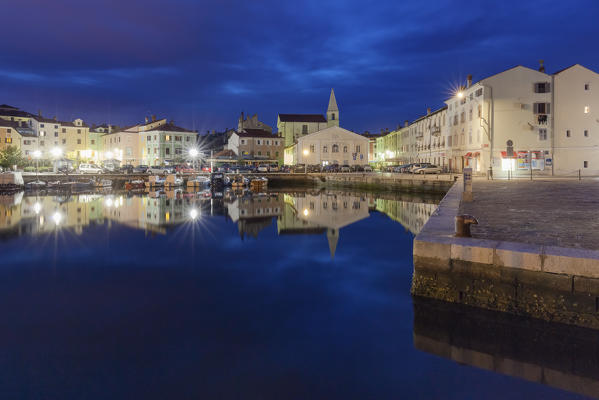 Europe, Slovenia, Primorska, Izola. Old town and the harbour with fishing boats at night