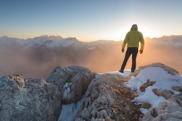 Europe, Italy, Veneto, Belluno, Agordino, Palazza Alta, Dolomites. Hiker on a mountain top admiring the sun setting