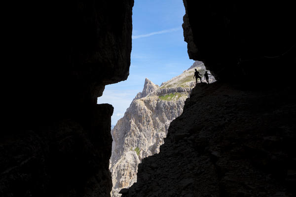 Italy, South Tyrol, Sexten, Hochpustertal, Bolzano. Hiker in silhouette on the Alpinisteig or Strada degli Alpini via ferrata, Sexten Dolomites