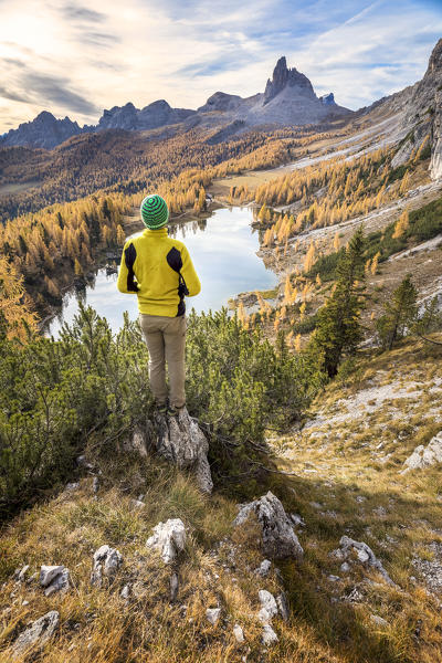 Hiker admiring the autumn colors at Federa lake, Cortina d Ampezzo, Belluno, Dolomites, Veneto, Italy