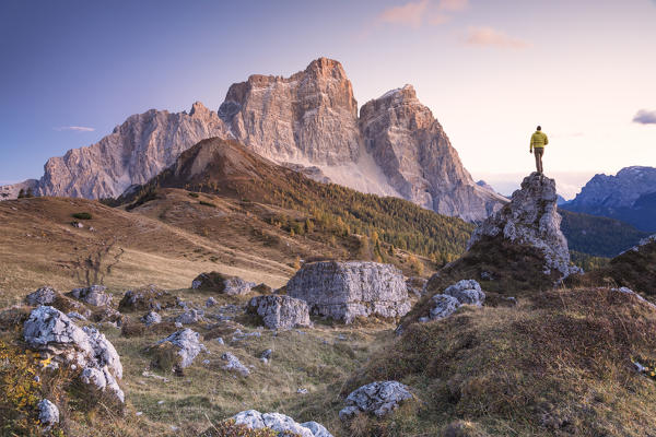 hiker on the alpine pasture of Alpe Prendera facing the north-west wall of the mount Pelmo, Col Roan, Dolomites, Borca di Cadore, Belluno, Veneto, Italy