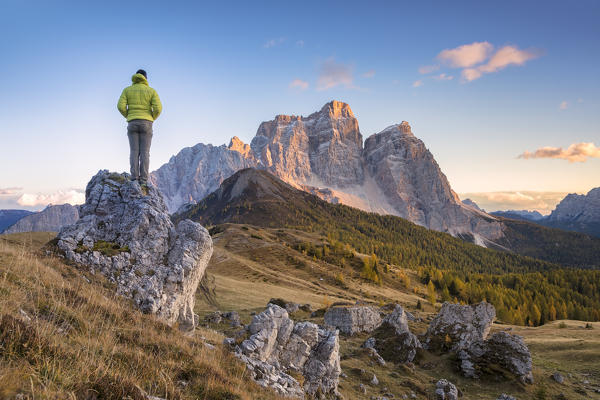 hiker on the alpine pasture of Alpe Prendera facing the north-west wall of the mount Pelmo, Col Roan, Dolomites, Borca di Cadore, Belluno, Veneto, Italy