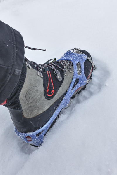 detail of a winter footwear with mounted trekking crampons, Agordino, Dolomites, Belluno, Veneto, Italy