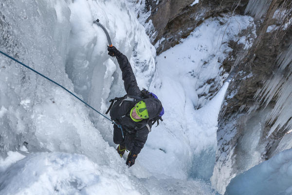 Ice climber on the Bordina waterfall, San Lucano valley, Taibon Agordino, Belluno, Veneto, Italy