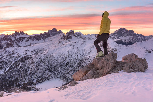 Ski-tourer in dolomites admiring the sunrise on the mountains, Cortina d'Ampezzo, Belluno, Veneto, Italy