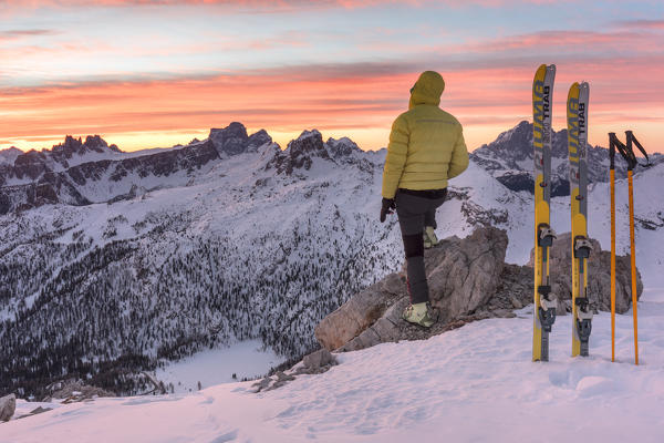 Ski-tourer in dolomites admiring the sunrise on the mountains, Cortina d'Ampezzo, Belluno, Veneto, Italy (MR)