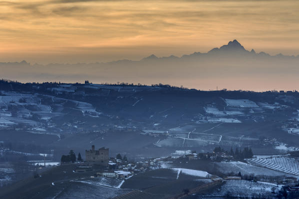 Langhe, Cuneo district, Piedmont, Italy. Langhe wine region winter snow, sunset over the Grinzane castle
