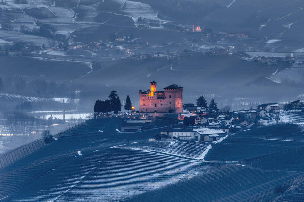Langhe, Cuneo district, Piedmont, Italy. Langhe wine region winter snow, blue hour at the castle of Barolo
