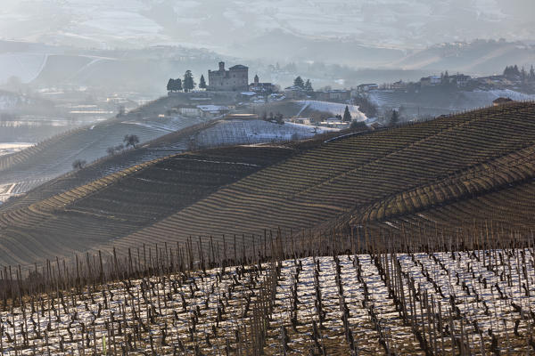 Langhe, Cuneo district, Piedmont, Italy. Langhe wine region winter snow,sunset over the Grinzane castle
