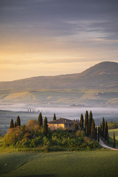 A farmhouse in the  morning between Val d'Orcia Hills. San Quirico d'Orcia, Val d'Orcia, Siena Province, Tuscany, Italy.