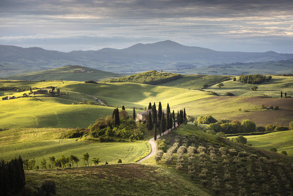 A farmhouse in the  morning between Val d'Orcia Hills. San Quirico d'Orcia, Val d'Orcia, Siena Province, Tuscany, Italy.