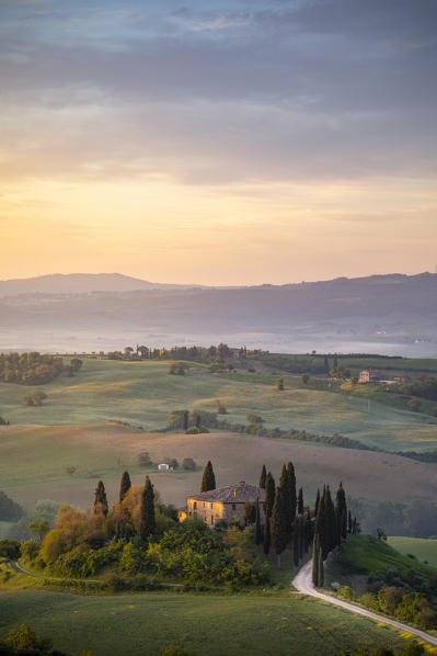 Farmhouse at sunrise near San Quirico d'Orcia, Siena Province, Tuscany, Italy.