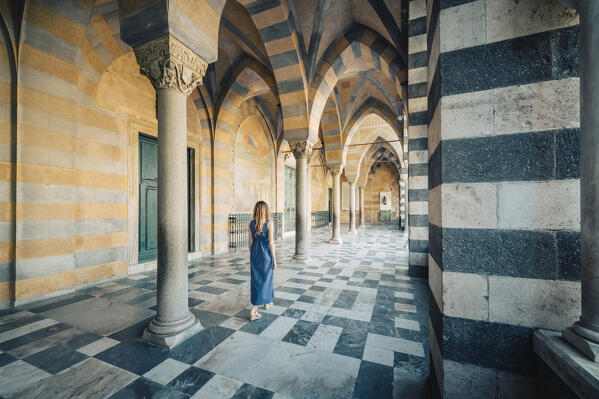 Blonde girl walking in Amalfi cathedral. Amalfi, Amalfi Coast, Sorrento province, Campania, Italy.