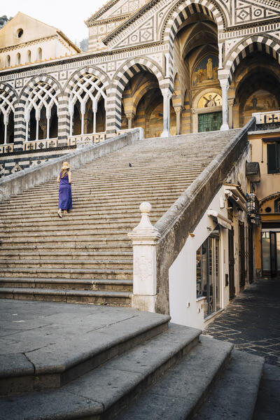 Blonde girl walking in Amalfi cathedral. Amalfi, Amalfi Coast, Sorrento province, Campania, Italy.