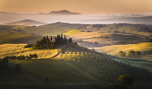 Podere Belvedere, San Quirico d'Orcia, Tuscany, Italy. Sunrise over the farmhouse and the hills.