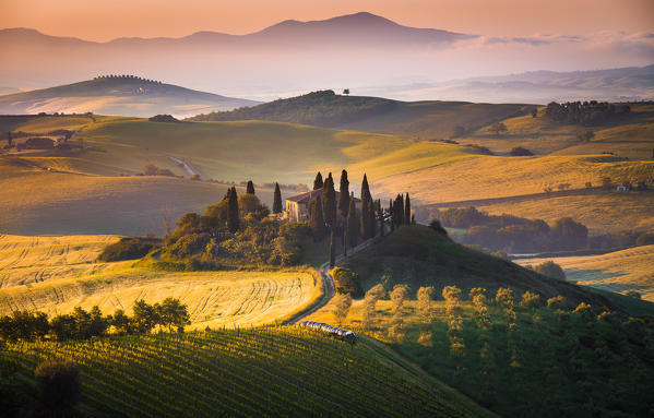 Podere Belvedere, San Quirico d'Orcia, Tuscany, Italy. Sunrise over the farmhouse and the hills.