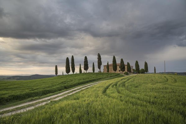 San Quirico d'Orcia, Tuscany, Italy. A farmhouse at sunset, during a stormy day.