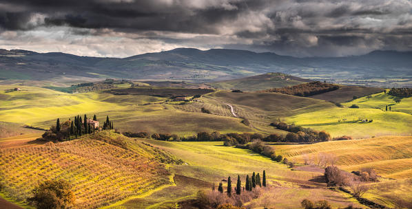 San Quirico d'Orcia, Tuscany, Italy. Sunlight over the farmhouse and the hill