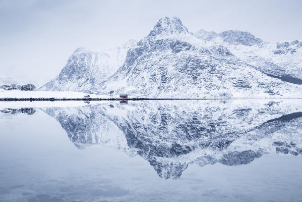 Iconic rorbuer reflecting itself on a lake, Lofoten Island, Norway
