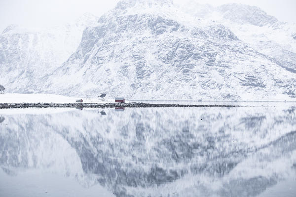 Perfect reflection of mountains and red house, Lofoten Islands, Norway