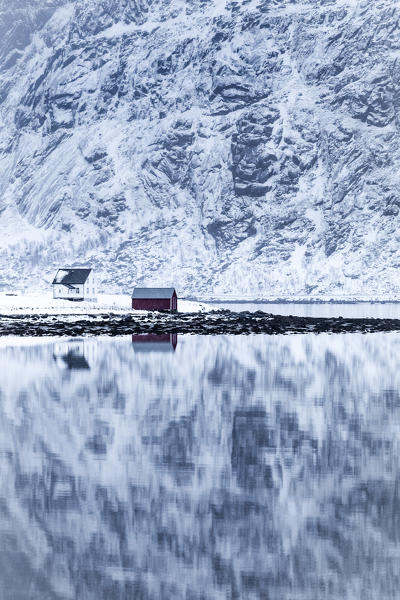 Perfect reflection of mountains and red house, Lofoten Islands, Norway