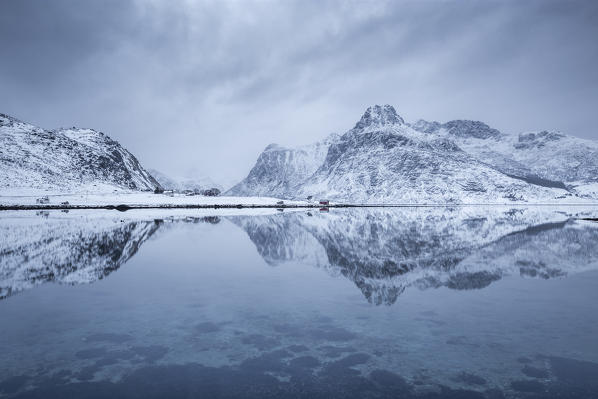 Perfect reflection of mountains and red house, Lofoten Islands, Norway