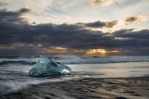 A stranded iceberg on Jokulsarlon black beach in Southern Iceland depicted ad long exposure.
