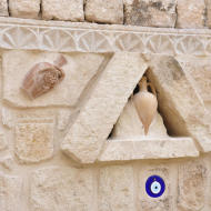 Typical sculpture on the wall on the old houses of Kappadokia region in Turkey. In these sculpture are represented the 'pottery' that are vases of terracotta and in blue color the Allah eye. The Allah eye has the aim to protect.