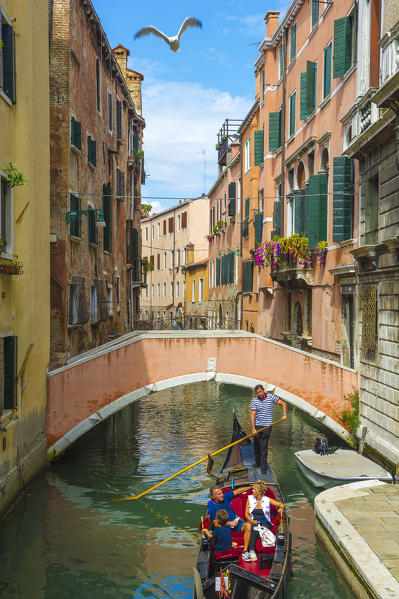 Venice, Veneto, Italy. Gondola sailing through a street canal.