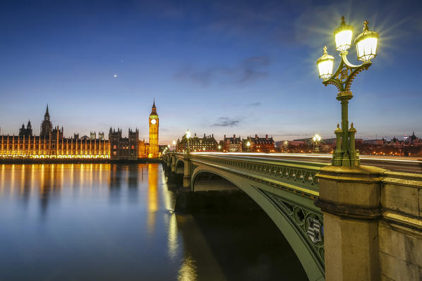 Night view of Palace of Westminster and Big Ben reflecting on Thames river.