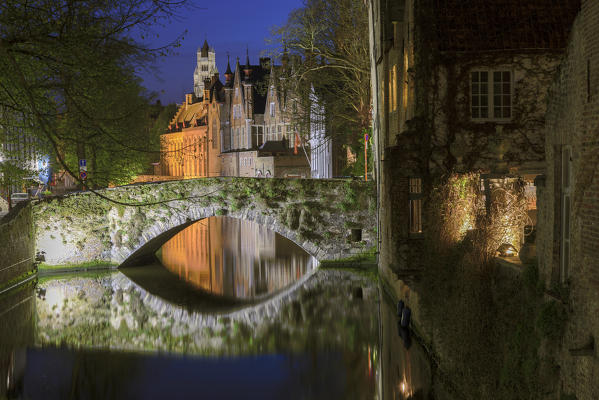 Night view of the medieval buildings of the city centre reflected in the typical canal Bruges West Flanders Belgium Europe