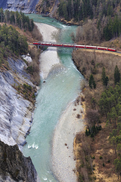 The Red Train crossing a bridge that used to cross the Rhine River. Rhein Gorge(Ruinaulta), Flims, Imboden, Graubunden, Switzerland, Europe