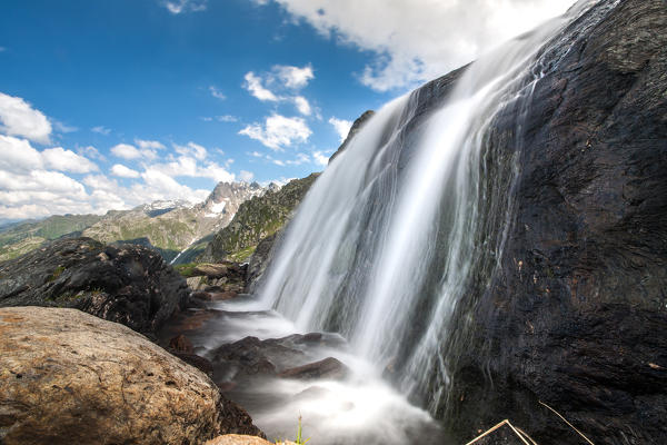 A waterfall with mountains in the background Orobie alps, Valtellina, Lombardy, Italy