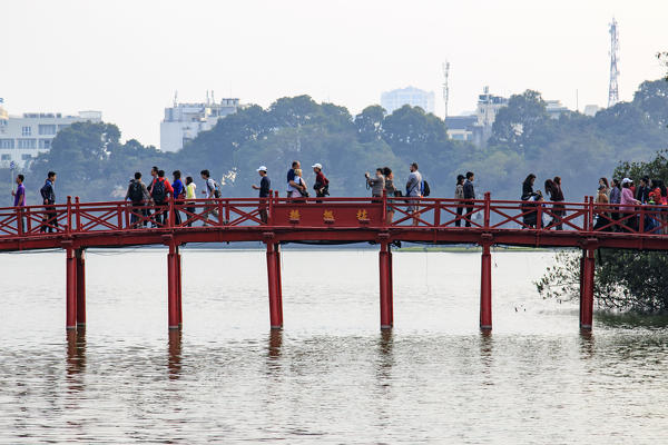 People walking on the Huc Bridge over the Hoan Kiem Lake