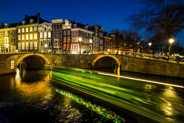 Amsterdam, Netherlands, Europe. Canal and light trails of a vessel.